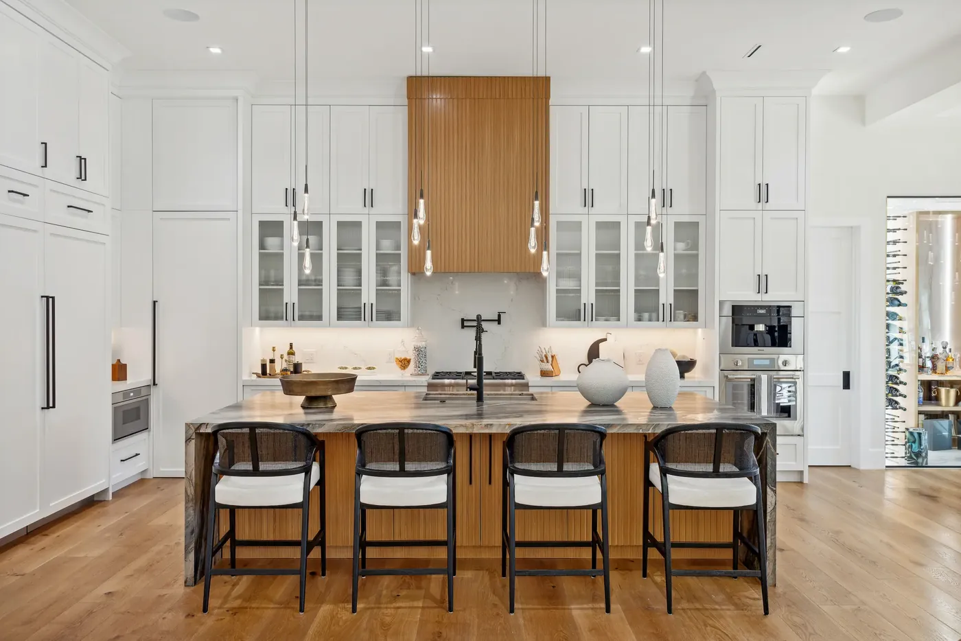 Kitchen with white cabinetry and a stone island in a Bluffton home by M&H Construction & Design