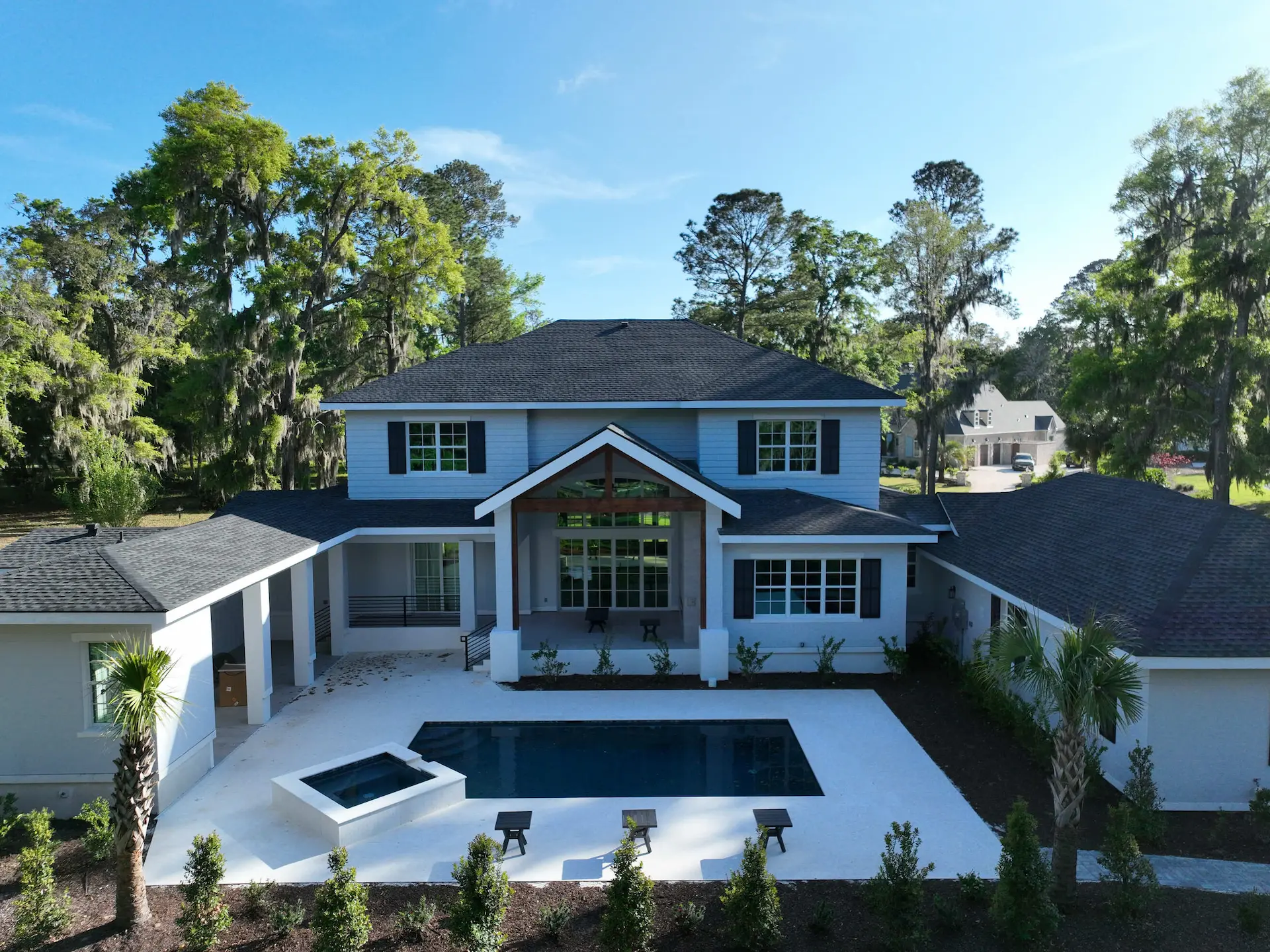 Lumina Luxe rear exterior with covered porch, landscaping, and swimming pool
